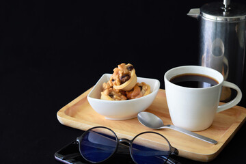 set of coffee and french press coffee maker on wood tray on black background with copy space