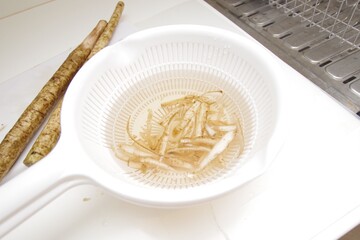 ササガキした牛蒡を水に浸してアク抜きしている