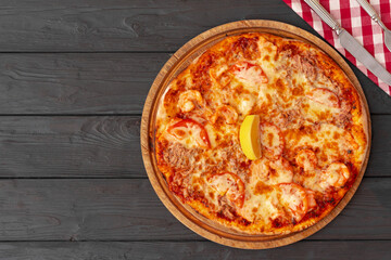 Tasty pizza on black wooden background top view