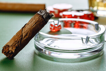 Fototapeta premium Close up of cigar and red dice cubes, gambling concept