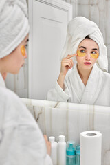 Naklejka premium beautiful woman with eye patches in white bathrobes in bathroom
