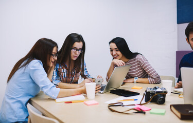 Coworkers sharing smartphone while resting in office