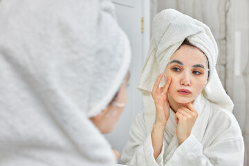 Obraz na płótnie Canvas woman in white bathrobe in front of mirror in bathroom