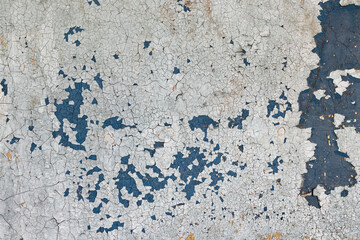 White-blue cracked paint on concrete wall