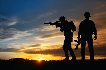 Silhouette of a soldiers against the sunrise. Concept - protection, patriotism, honor.