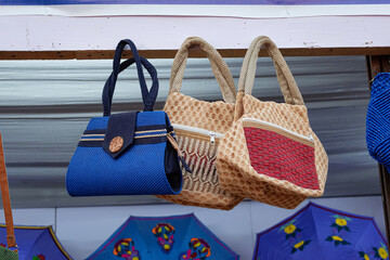 Beautiful handmade colourful jute bags are displayed in a shop for sale in blurred background. Indian handicraft