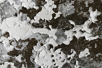 White cracked wallpaper on molded concrete wall