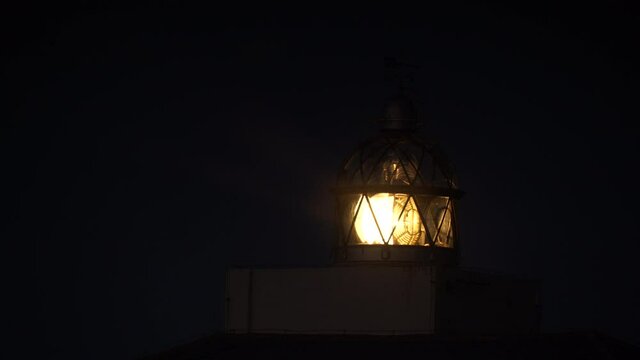 Detail view. Lighthouse with beacon light in the night. Faro Cabo Busto on Asturias coast in Spain. Tourist attraction, place to visit.