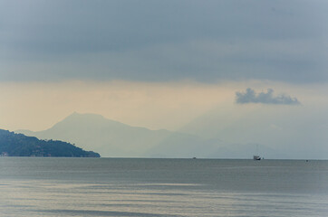 View of Paraty's sea with some clouds in the sky and boats on the water.