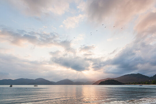 Colorful sunset view in dusk beach tropical summer climate with mountains in the background