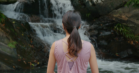 Sport woman look at the waterfall