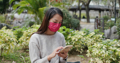Woman wear face mask and use of smart phone at outdoor