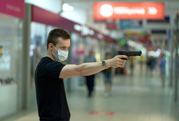 A man with a mask in a mall threatens with a gun