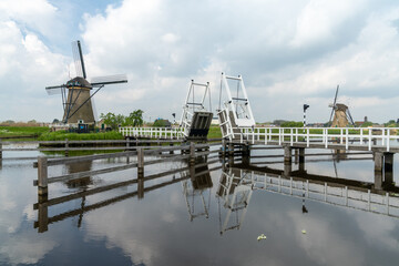 Fototapeta na wymiar picturesque wooden draw bridge and windmills on the canals of South Holland