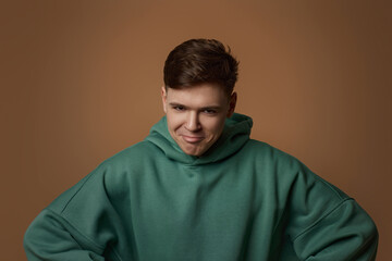 young man frowning on brown background. facial expressions