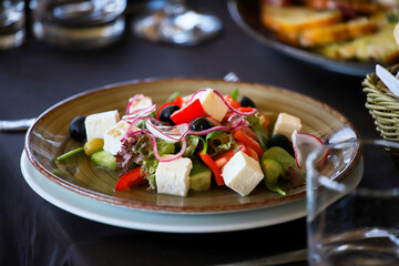 Salad of cheese, paprika, onions, olives on a banquet table in a restaurant.