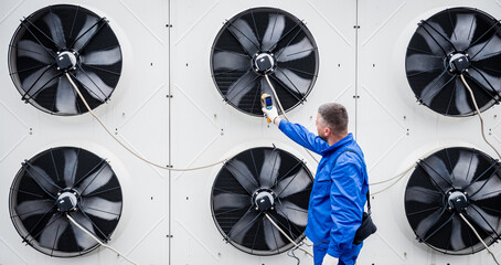 Technician uses a thermal imaging infrared thermometer to check the condensing unit heat exchanger.