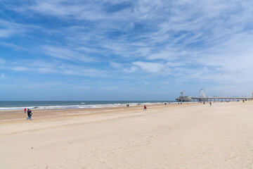 Fototapeta na wymiar people enjoy a sunny day on the beach at the Dutch seaside resort of Scheveningen near The Hague