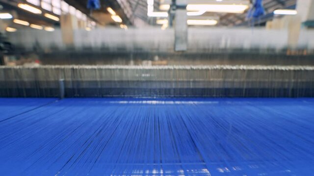 Factory mechanism is weaving with blue threads