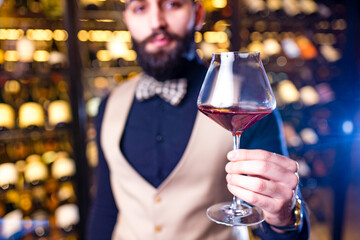 happy successful male winemaker is tasting a flavor and checking red wine quality