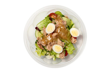 Fresh tuna salad with lettuce, cucombers, cherries and eggs in plastic container.