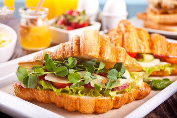 Croissant sandwiches with ham, cheese greens. Breakfast concept.
