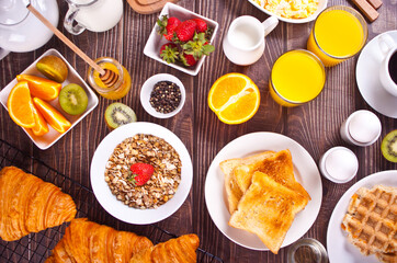 Croissant, Muesli, toasts, fruits, eggs, waffles and cup of coffee on the background. Breakfast concept. Top view
