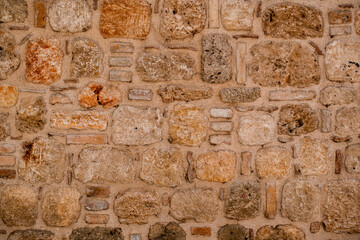 exterior wall with masonry of natural stone blocks of shell rock of different shapes