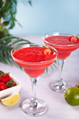 Cold strawberry margarita or daiquiri cocktail with lime and rum