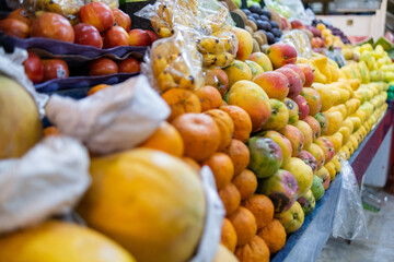 Colorful fruit stand with papayas, tangerines, apples, mangoes and more