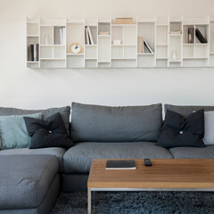 White shelf above gray sofa