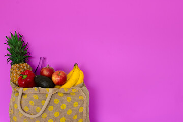 Bolsa de mercado con frutas en fondo rosa