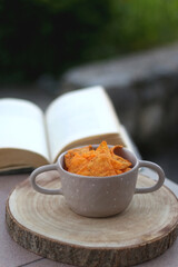 Bowl of spicy tortilla chips and open book in a garden. Selective focus.