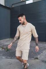 Chico joven atletico posando con ropa urbana en entornos de ciudad