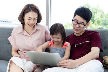 Fototapeta premium Girls with cerebral palsy learn, laugh, play father and mother in the white bedroom teach to see teaching materials and learning development of disabled children with Notebook. Happy education concept