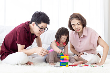 Disabled the kid and father, mother playing together with wooden toys.