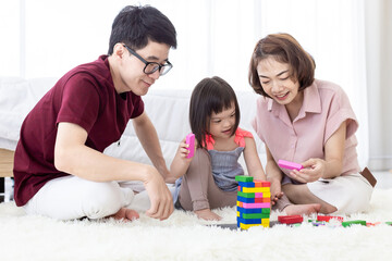 Disabled the kid and father, mother playing together with wooden toys.