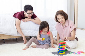 Disabled the kid and father, mother playing together with wooden toys.