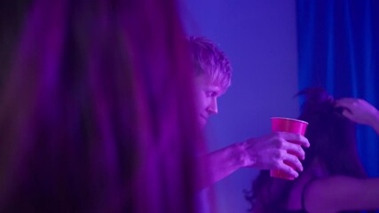 Group of students singing and dancing at home, having party during coronavirus lockdown, dance together in living room at night. Young friends millenials celebrate birthday holiday.