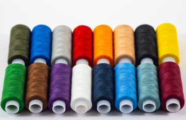 Several multi-colored bobbins with thread isolated on white background.