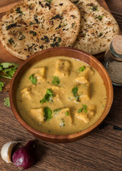 Indian shahi paneer cottage cheese in tomato cream sauce with cheese naan