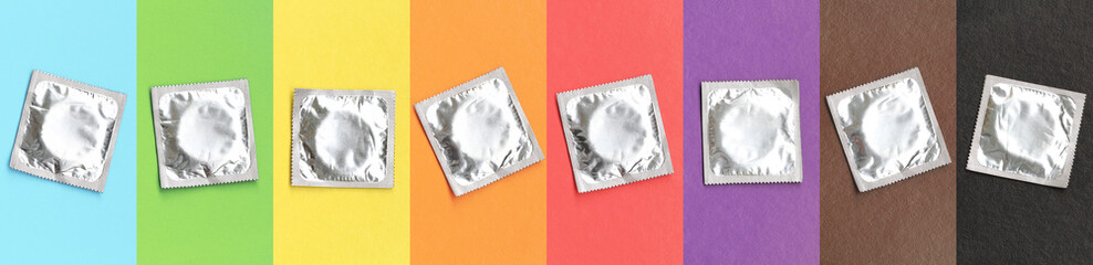 Condoms in packaging on a rainbow background, pastel multicolored shades, aids prevention concept,...