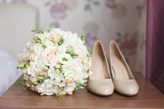 Wedding classic accessories: Bride's beige shoes, rings, boutonniere and wedding bouquet. Bridal accessories
