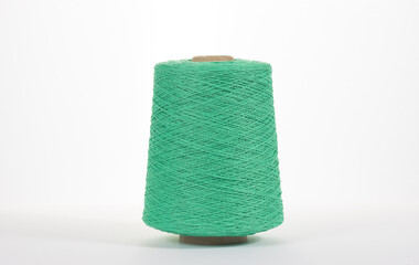Green spool with cotton thread on white isolated background.