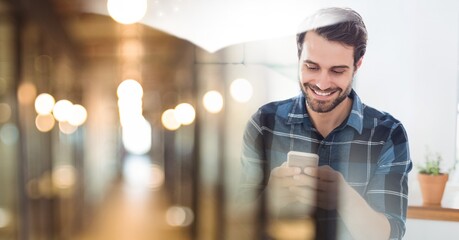 Composition of smiling man using smartphone in office with blurred overlay