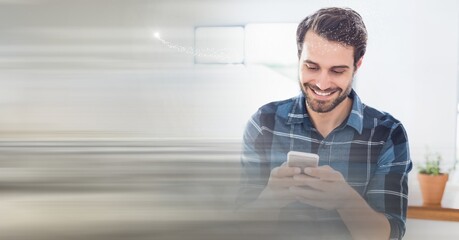 Composition of smiling man using smartphone in office with blurred overlay
