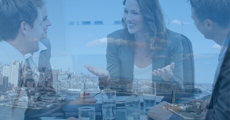 Fototapeta premium Composition of businesswoman in meeting with businessmen over cityscape