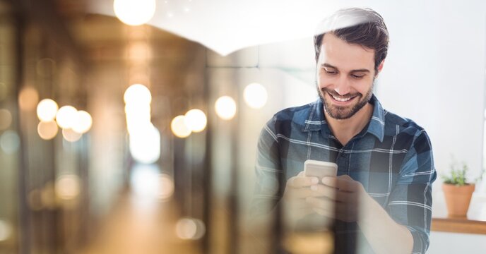 Composition of smiling man using smartphone in office with blurred overlay