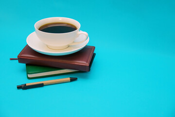 Two leather-bound notebooks lie on top of each other on a blue background.