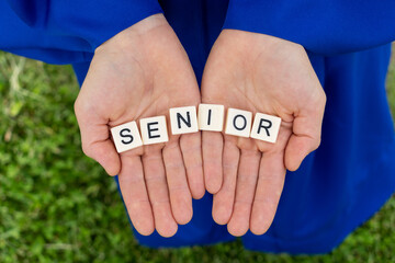a senior holding the letters in their hands
